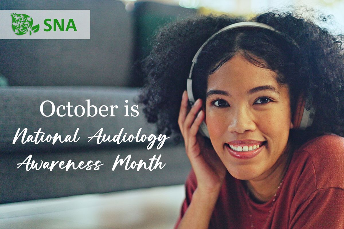 woman wearing headphones smiling for October is National Audiology Awareness Month.