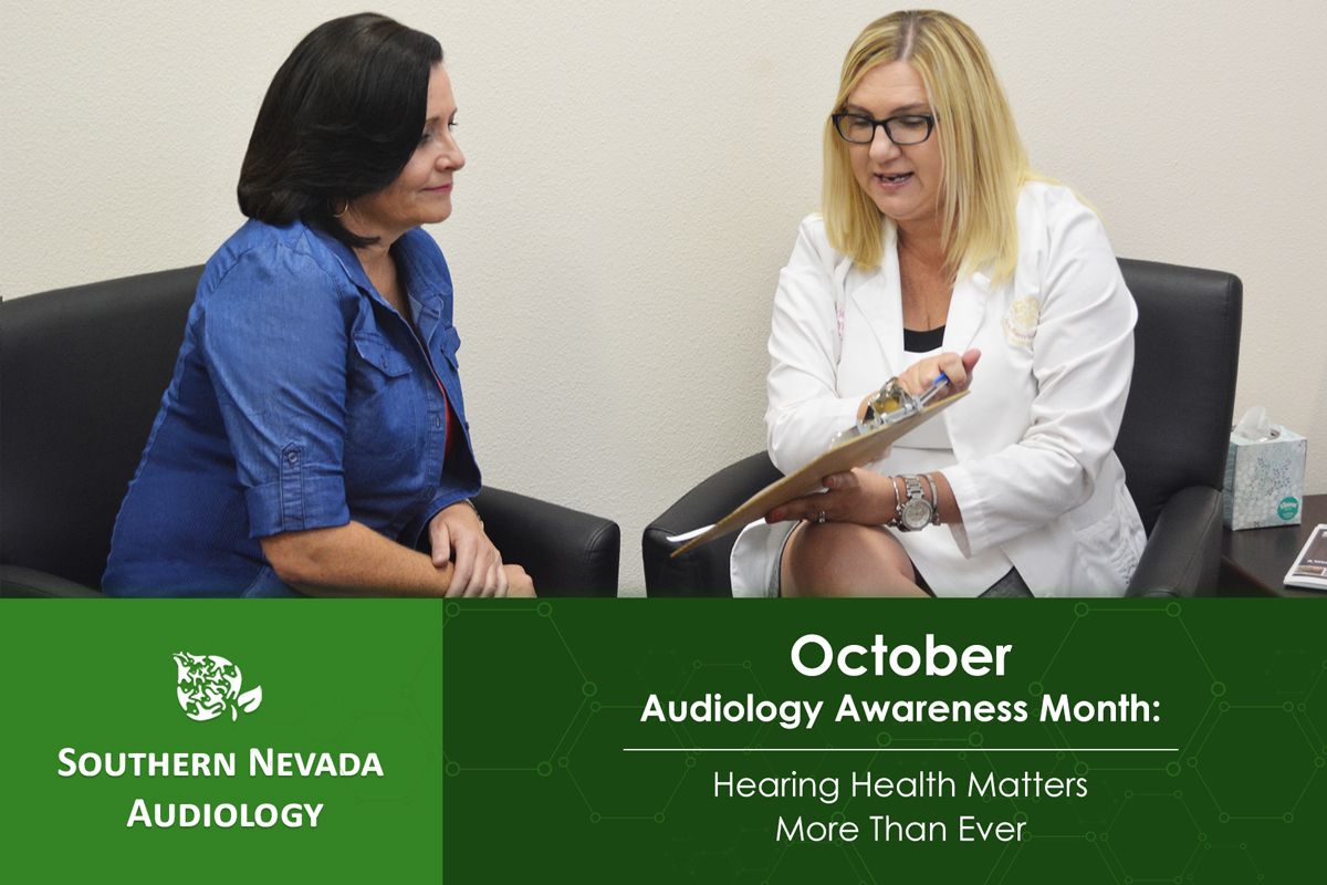 audiologist sitting with patience reviewing audiology tests