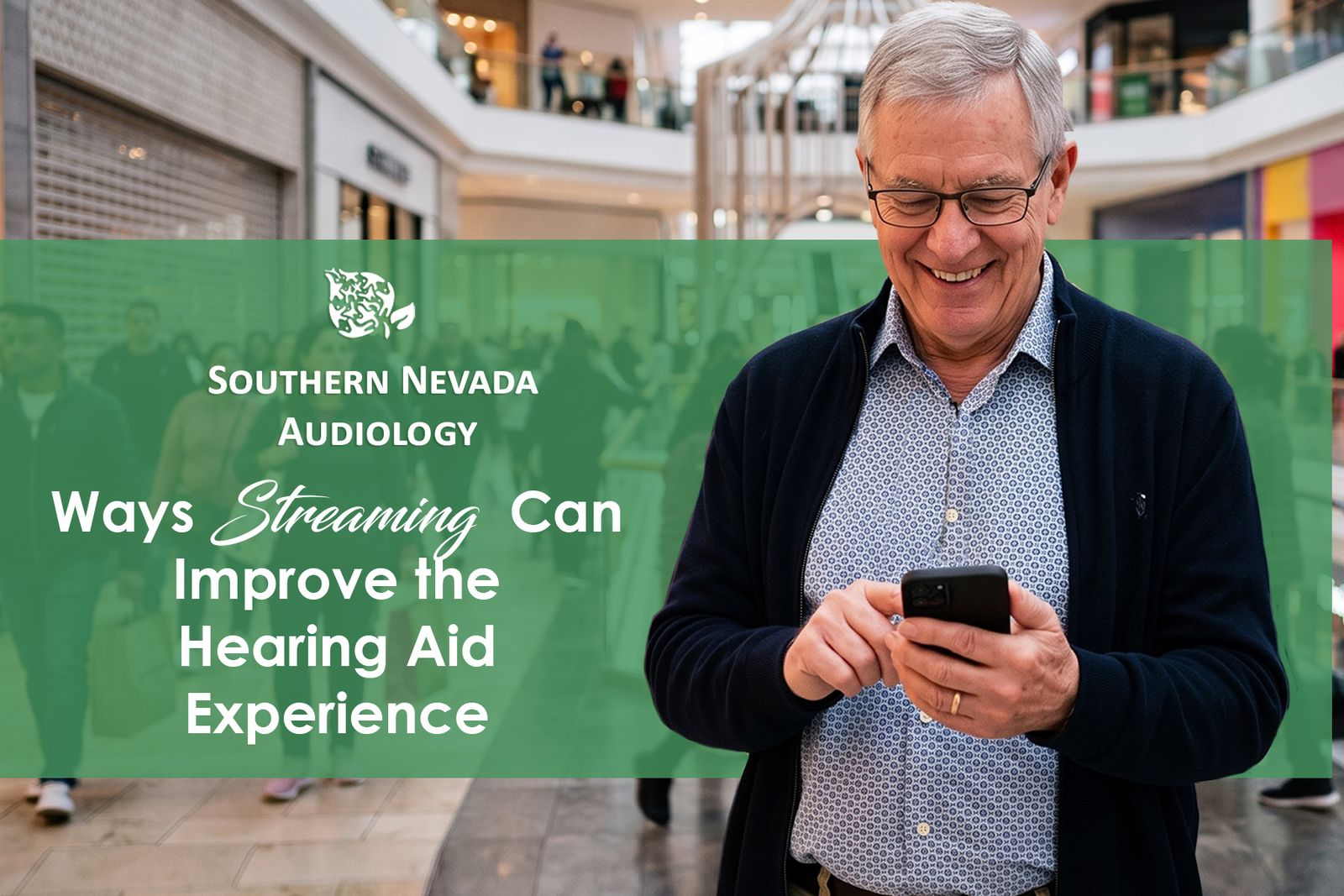 senior man smiling in mall while working streaming services on his cell phone for his hearing aid.