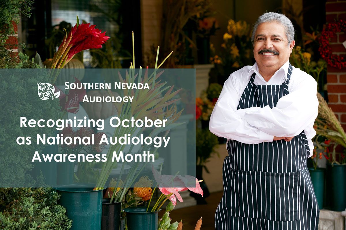 Smiling man in a striped apron outside a flower shop, with the words Recognizing October as National Audiology Awareness Month.